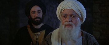 Movie still from “The Message” (1976), directed by Moustapha Akkad – A man with a beard and a turban and another man with a beard and a turban; Medium shot, Over the shoulder angle