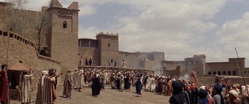 Movie still from “The Message” (1976), directed by Moustapha Akkad – A group of people walking down a street; Extreme Wide shot, Low angle
