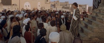Movie still from “The Message” (1976), directed by Moustapha Akkad – A group of people standing around a crowd of people; Wide shot, High angle