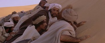 Movie still from “The Message” (1976), directed by Moustapha Akkad – A group of men in white robes and head scarfs; Medium shot, High angle