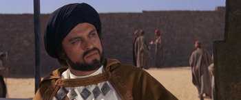 Movie still from “The Message” (1976), directed by Moustapha Akkad – A man with a beard wearing a turban; Close Up shot, Over the shoulder angle