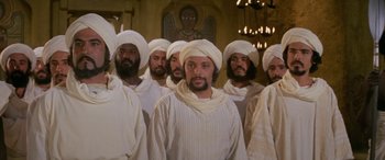 Movie still from “The Message” (1976), directed by Moustapha Akkad – A group of men standing next to each other in white robes; Medium shot, Low angle