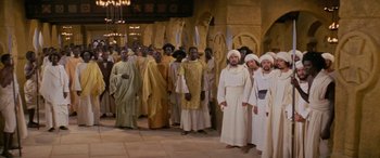 Movie still from “The Message” (1976), directed by Moustapha Akkad – A group of men in white robes standing next to each other; Wide shot, High angle