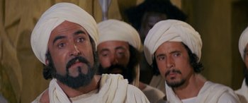 Movie still from “The Message” (1976), directed by Moustapha Akkad – A group of men wearing white turbans and beards; Close Up shot, Over the shoulder angle