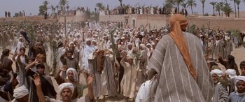 Movie still from “The Message” (1976), directed by Moustapha Akkad – A group of people standing in the middle of a field; Extreme Wide shot, High angle