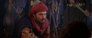 Movie still from “The Message” (1976), directed by Moustapha Akkad – A man with a red turban is looking at the camera; Close Up shot, Over the shoulder angle