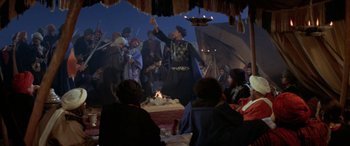 Movie still from “The Message” (1976), directed by Moustapha Akkad – A group of people sitting around a tent; Wide shot, High angle