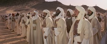 Movie still from “The Message” (1976), directed by Moustapha Akkad – A group of men standing next to each other; Wide shot, Low angle