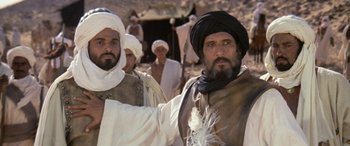 Movie still from “The Message” (1976), directed by Moustapha Akkad – A group of men standing next to each other in a field; Medium shot, Low angle
