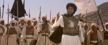 Movie still from “The Message” (1976), directed by Moustapha Akkad – A group of men standing next to each other on a field; Medium shot, Low angle