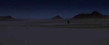 Movie still from “The Message” (1976), directed by Moustapha Akkad – A person is walking in the desert at night; Extreme Wide shot, High angle
