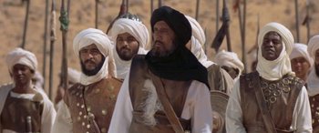 Movie still from “The Message” (1976), directed by Moustapha Akkad – A group of men standing next to each other in a field; Medium shot, Low angle