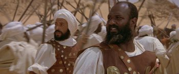 Movie still from “The Message” (1976), directed by Moustapha Akkad – A group of men standing next to each other; Medium shot, Low angle