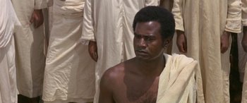 Movie still from “The Message” (1976), directed by Moustapha Akkad – A man with a towel around his neck; Close Up shot, High angle