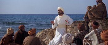 Movie still from “The Message” (1976), directed by Moustapha Akkad – A man dressed as jesus standing next to the ocean; Medium shot, Over the shoulder angle