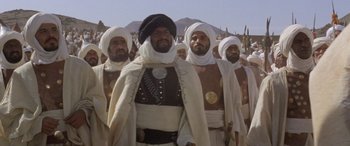 Movie still from “The Message” (1976), directed by Moustapha Akkad – A group of men standing next to each other; Medium shot, Low angle