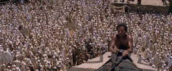 Movie still from “The Message” (1976), directed by Moustapha Akkad – A large group of people standing around a building; Extreme Wide shot, High angle