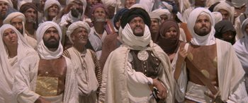 Movie still from “The Message” (1976), directed by Moustapha Akkad – A group of men standing around each other in a crowd; Medium shot, Low angle