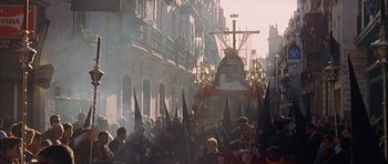 Movie still from “The Moment of Truth” (1965), directed by Francesco Rosi – A group of people walking down a street with a statue; Extreme Wide shot, High angle