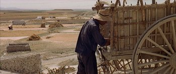 Movie still from “The Moment of Truth” (1965), directed by Francesco Rosi – A man in a straw hat working on a wooden structure; Wide shot, High angle