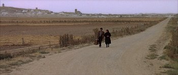 Movie still from “The Moment of Truth” (1965), directed by Francesco Rosi – A man and a woman walking down a dirt road; Extreme Wide shot, High angle