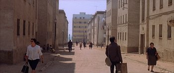 Movie still from “The Moment of Truth” (1965), directed by Francesco Rosi – A group of people walking down a street; Extreme Wide shot, High angle