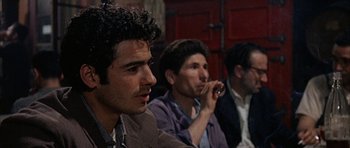 Movie still from “The Moment of Truth” (1965), directed by Francesco Rosi – A group of men sitting next to each other in a room; Close Up shot, Over the shoulder angle