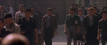 Movie still from “The Moment of Truth” (1965), directed by Francesco Rosi – A group of men walking down a street; Wide shot, Over the shoulder angle