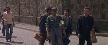 Movie still from “The Moment of Truth” (1965), directed by Francesco Rosi – A group of men walking down a sidewalk; Wide shot, High angle