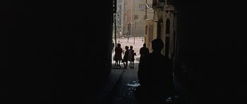 Movie still from “The Moment of Truth” (1965), directed by Francesco Rosi – A group of people walking down a street; Wide shot, High angle