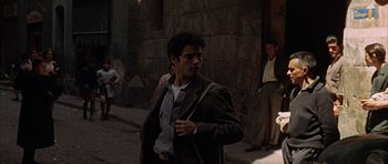 Movie still from “The Moment of Truth” (1965), directed by Francesco Rosi – A man in a brown jacket is walking down the street; Medium shot, Over the shoulder angle