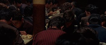 Movie still from “The Moment of Truth” (1965), directed by Francesco Rosi – A group of people sitting around a table; Medium shot, High angle