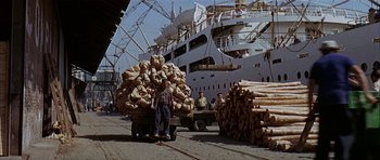 Movie still from “The Moment of Truth” (1965), directed by Francesco Rosi – A man standing next to a truck filled with wood; Wide shot, High angle
