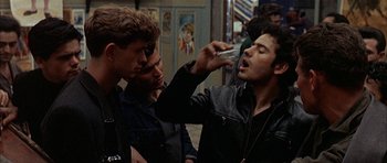 Movie still from “The Moment of Truth” (1965), directed by Francesco Rosi – A man is taking a picture of another man with a phone; Medium shot, Over the shoulder angle