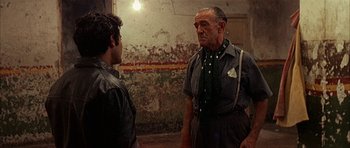 Movie still from “The Moment of Truth” (1965), directed by Francesco Rosi – A man and a man standing next to each other; Medium shot, Over the shoulder angle