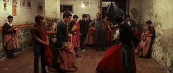 Movie still from “The Moment of Truth” (1965), directed by Francesco Rosi – A group of people standing around in a room; Wide shot, High angle