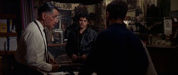 Movie still from “The Moment of Truth” (1965), directed by Francesco Rosi – A group of men standing around a table; Medium shot, Over the shoulder angle