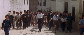 Movie still from “The Moment of Truth” (1965), directed by Francesco Rosi – A crowd of people walking down a street; Wide shot, High angle