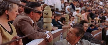 Movie still from “The Moment of Truth” (1965), directed by Francesco Rosi – Two men are talking to each other in a crowd; Medium shot, Over the shoulder angle