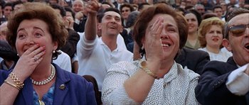 Movie still from “The Moment of Truth” (1965), directed by Francesco Rosi – A woman and a man in a crowd clapping; Close Up shot, High angle