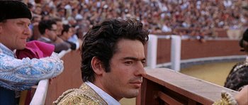 Movie still from “The Moment of Truth” (1965), directed by Francesco Rosi – A person with a crowd in the background; Close Up shot, Low angle