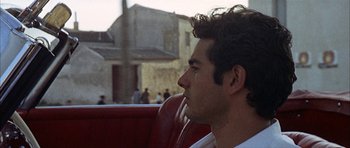 Movie still from “The Moment of Truth” (1965), directed by Francesco Rosi – A person sitting in a vehicle; Close Up shot, Over the shoulder angle