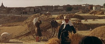 Movie still from “The Moment of Truth” (1965), directed by Francesco Rosi – A woman standing next to a horse drawn carriage; Wide shot, Low angle