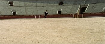Movie still from “The Moment of Truth” (1965), directed by Francesco Rosi – A man running across an empty field with an empty wall behind him; Extreme Wide shot, High angle