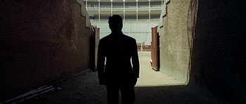 Movie still from “The Moment of Truth” (1965), directed by Francesco Rosi – A man in a suit standing in an alleyway; Wide shot, High angle