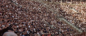 Movie still from “The Moment of Truth” (1965), directed by Francesco Rosi – A crowd of people sitting in the bleachers at a sporting event; Extreme Wide shot, High angle