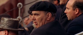 Movie still from “The Moment of Truth” (1965), directed by Francesco Rosi – An older man wearing a black hat and jacket; Close Up shot, Over the shoulder angle