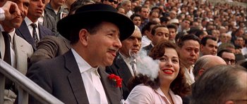 Movie still from “The Moment of Truth” (1965), directed by Francesco Rosi – A crowd of people sitting in a stadium with smoke coming out of their mouth; Close Up shot, High angle