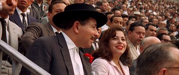 Movie still from “The Moment of Truth” (1965), directed by Francesco Rosi – A man and a woman sitting next to each other in a crowd; Close Up shot, High angle