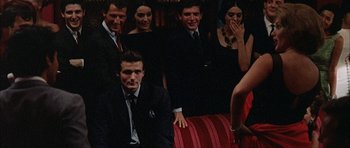 Movie still from “The Moment of Truth” (1965), directed by Francesco Rosi – A group of men and women posing for a picture; Medium shot, Over the shoulder angle